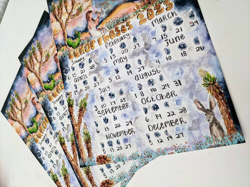 2023 Lunar Wall Calendar with desert themes like Joshua Trees, moon, mountains, cactuses, and desert animals sized 8.5x11"